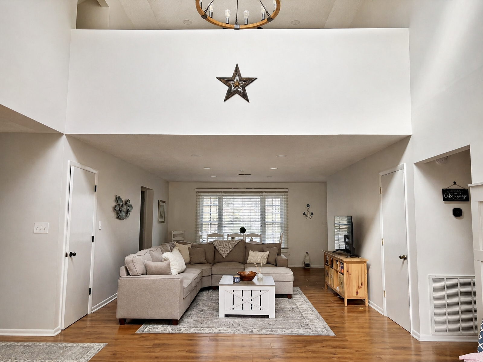 Vaulted living room at Beaches Be Salty with sectional sofa, dining area, and star wall decor